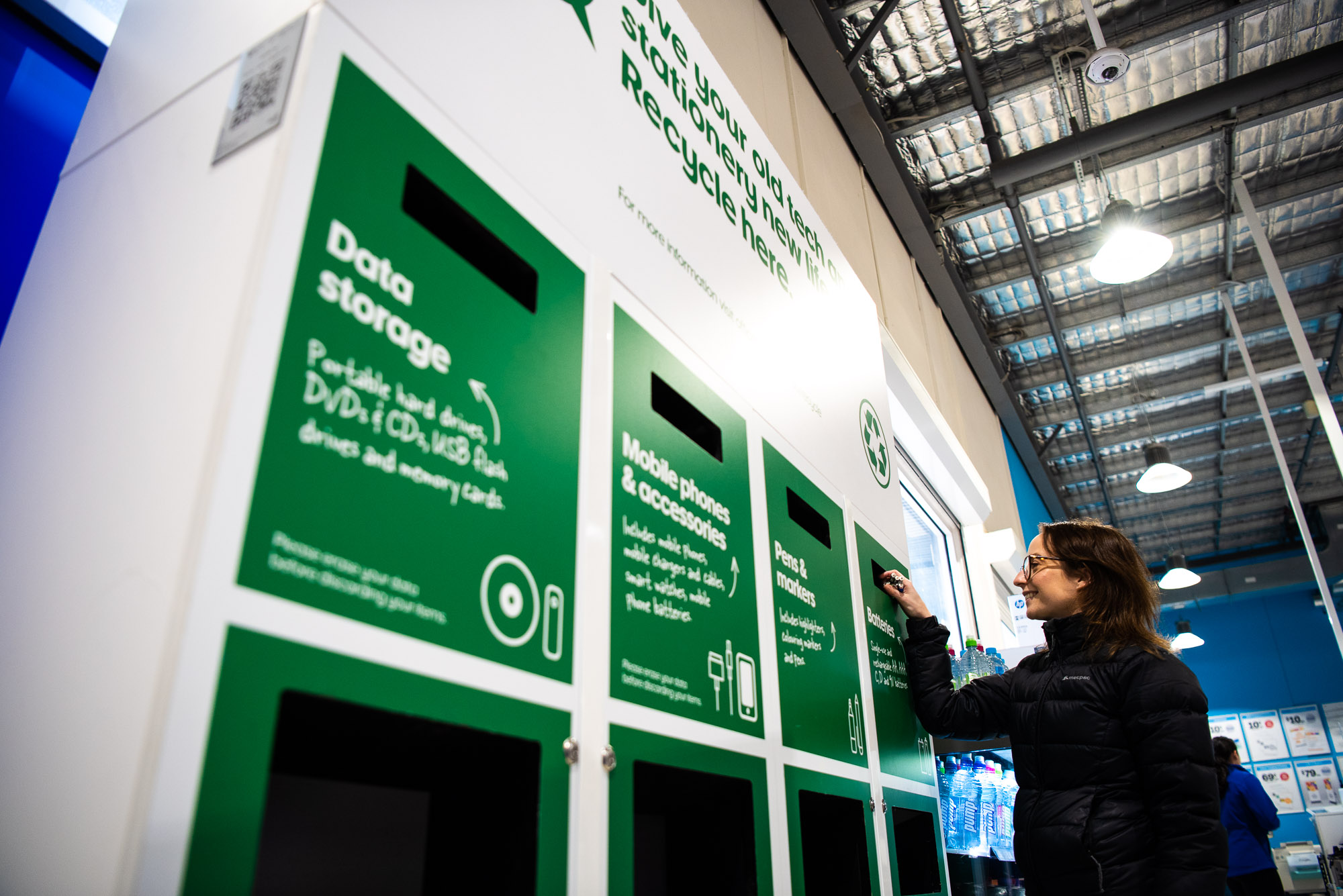 Customer recycling batteries at recycling station